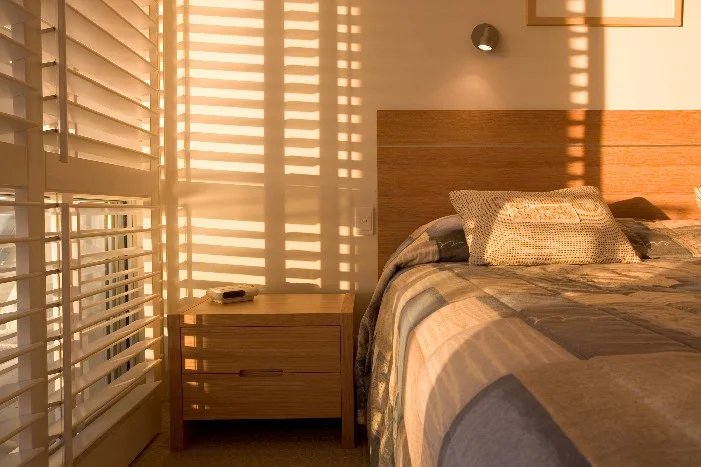 Sonnenbeschienes Schlafzimmer mit Jalousien